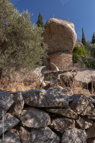 Unique anti pirate stone house with giat rock boulder on the Greek Island of Ikaria