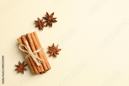 Aromatic cinnamon sticks and anise stars on a color background