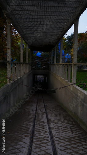 Cabane, demeure et bati, maison de rangement de matériel ou de machineries de jardin, coin secret et discret, des grilles métalliques, barreaux, accès réservé et restreint, parc public, feuilles morte