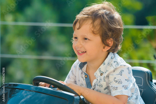 Kid Driver. Cute little baby boy pretending to drive. Kid in car with hands on the wheel. Baby Driver. Little kid driving car. Kid Sitting At The Wheel. Child playing with car. Dream, imagination.