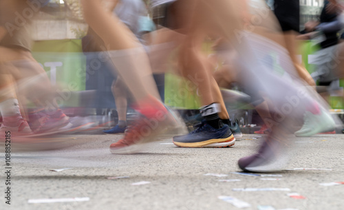 Closeup long exposure many persons and legs running marathon race stock photo with space for text non recognizable people on it