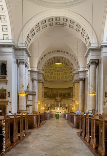 Trieste, Italy - June 27, 2024: Looking along nave to main altar in chancel at Church of Sant'Antonio Nuovo. People on benches