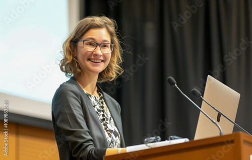 Pewna siebie kobieta w okularach przemawiająca na konferencji lub prezentacji.