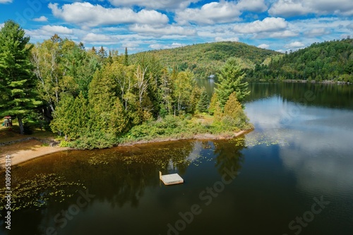 A pontoon in the calm Lac Raymond, and forest in the Laurentian Hills, Val-Morin, Quebec, Canada.