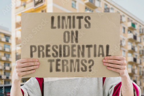 The phrase 'Limits on presidential terms?' on a banner in a person's hand. Human holds a cardboard with an inscription. Democracy. Governance. Authority. Leadership. Power. Politics. Election