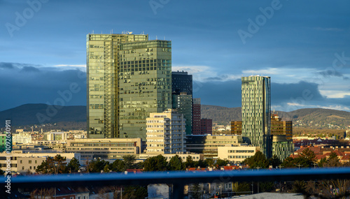 Vienna Twin tower on Wienerberg with 3 empty floors in the morning sun against a dark sky in the background