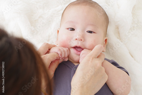 お布団に寝ころがるかわいい赤ちゃんとその母親