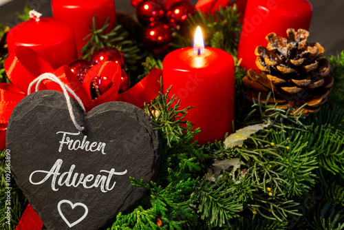 Adventsgrüße: Herz mit der Aufschrift FROHEN ADVENT vor einem Adventskranz