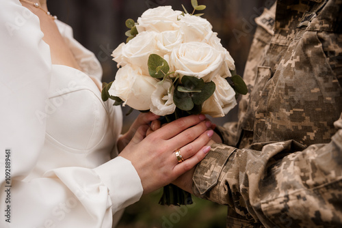 A Tender Moment: Bride and Groom Holding Hands with Wedding Bouquet