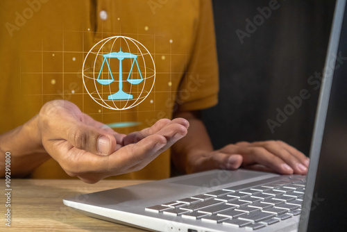 Man working on laptop and holding a virtual law or legal symbol