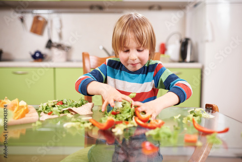 Smiling child playing with vegetables and a tortilla wrap in the kitchen, colorful striped shirt, messy table, fun and cheerful moment, healthy food preparation