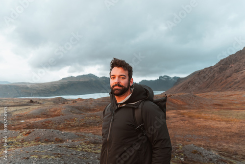 Male hiker with backpack enjoying breathtaking view of icelandic wilderness during golden hour sunset