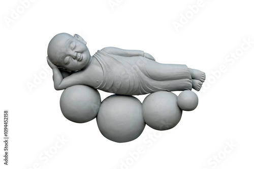 Cement statue of a novice monk sleeping on a round stone, isolated on white background. Reclining novice monk.