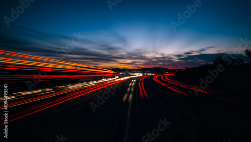 A long exposure shot of a busy freeway at sunset. The streaks of light from the cars create a colorful and abstract pattern.