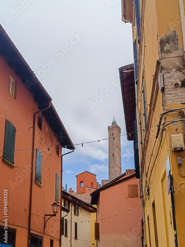 Perspective of colorful architectural buildings on the street and Asinelli tower in the background, Bologna ITALY