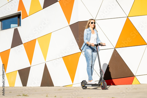 Mature woman riding an electric scooter on the sidewalk in the street. Sustainable urban mobility.