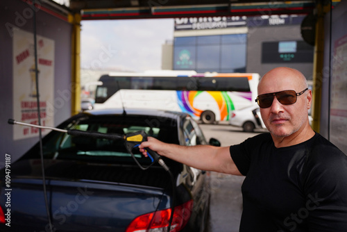 A man washed a blue-colored car at a touchless car wash