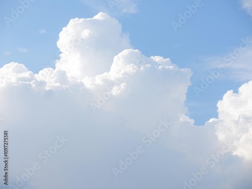 White fluffy clouds in a pale blue sky, creating a serene and heavenly atmosphere, peaceful, serene