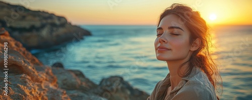 A serene woman enjoying a sunset by the ocean, exuding tranquility and peace amidst the beautiful coastal landscape.