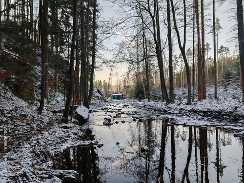 A serene winter view of the Doubravka River valley near Chotebor, featuring calm flowing waters, snow-covered rocks, and the natural beauty of the Czech countryside.