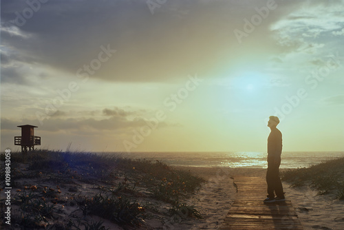 Man walking to the beach at sunset with lifeguard tower in background, analog 35mm