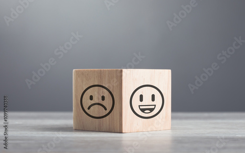 Wooden blocks displaying a sad face transitioning to a happy face, symbolizing a shift from negativity to positivity. Final block turns from sad to happy, highlighting the power of a positive outlook