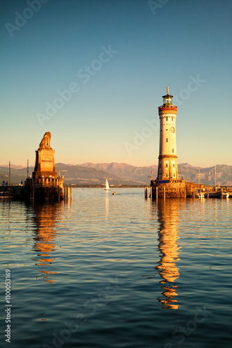 Lindau harbor entrance with monument and lighthouse at dusk