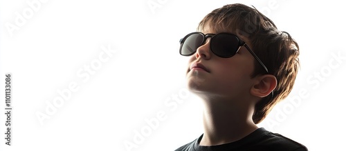 Young boy wearing stylish sunglasses with a confident expression against a bright white background in a portrait setting.