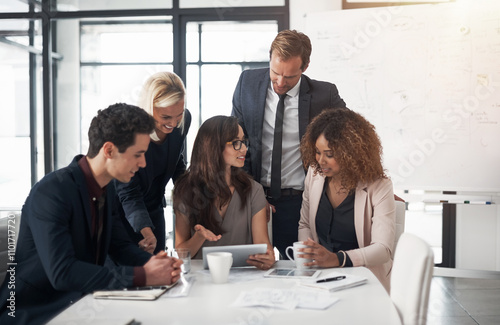 People, tablet and meeting in office for feedback, project management and positive review. Company team, tech and discussion in small business for planning, brainstorming and smile for startup growth