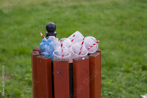 Puste plastikowe opakowania po napojach w śmietniku.