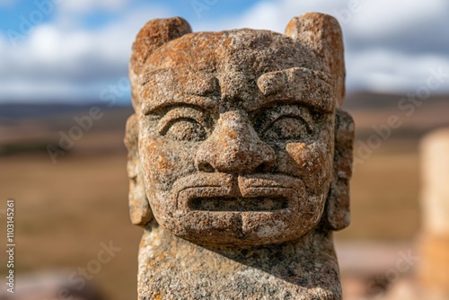 Ancient stone totem statue with animal ears against blurred nature landscape. Traditional Native American tribal art sculpture. Cultural heritage monument with copy space