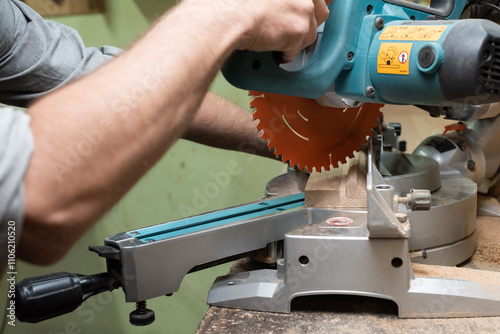 The carpenter saws off the end of the oak part with a circular saw