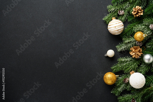 Christmas decorations and spruce tree at black background. Flat lay with copy space.