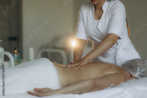 Process of trapezius muscles massage in pro salon, close-up. Therapist working with female body laying face down, movement, selective focus. Treatment, recovery, relax, manual therapy concept.