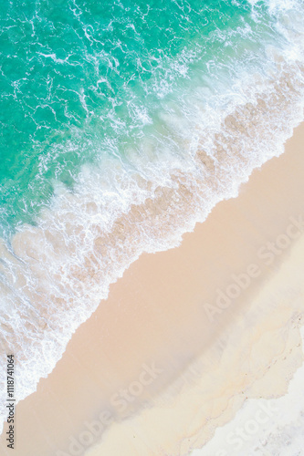 lonely paradisaical beach of clear sand and turquoise waters at sunrise, zenithal view from a drone