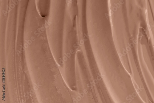 Creamy chocolate mixture swirled smoothly on a surface close-up, mocha mousse color 2025