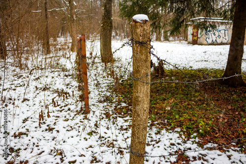 A makeshift fence made of barbed wire and posts around a closed-to-passage area