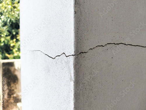 Cement cracks, long wavy lines at the corners of house pillars.