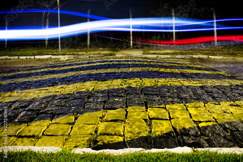 Traces of car headlights on a cobbled street