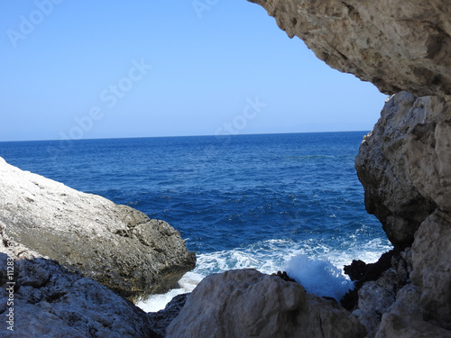 Tiefblaues Mittelmeer trifft schäumend auf eine felsige Bucht auf Rhodos