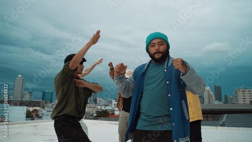 Multicultural hip-hop group dance together at rooftop with city view. Skilled hipster wear colorful outfit while multicultural friends or dance team dancing together. Outdoor sport 2024. Hiphop.